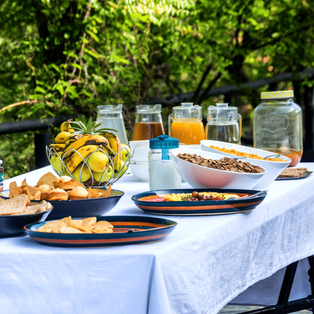 Breakfast laid out under the trees with fresh fruit, pastries and juice