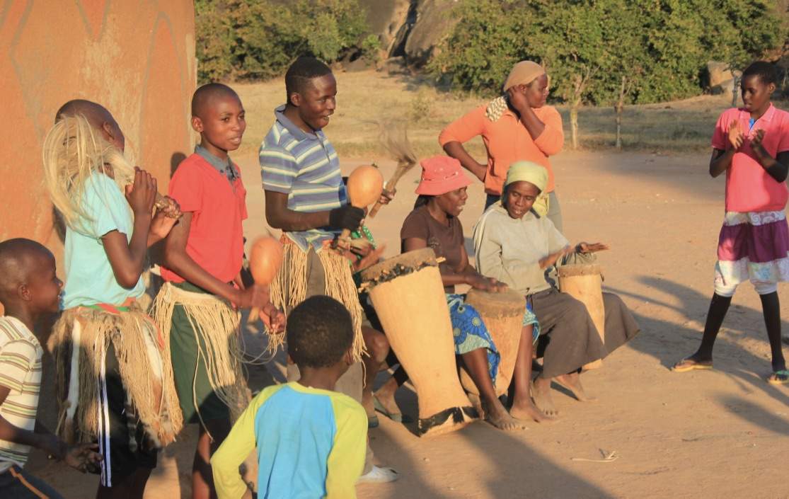 Children drumming and dancing at the homestead