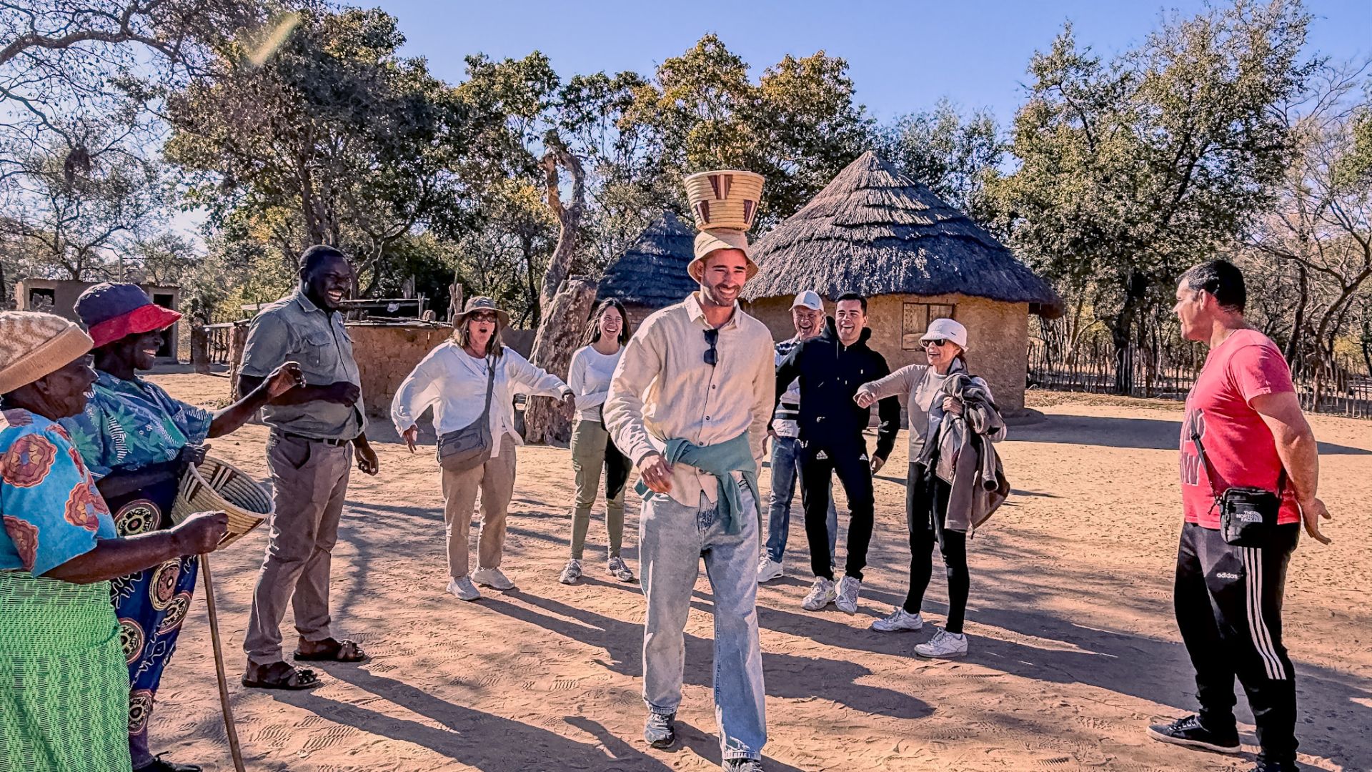 Guests sharing a meal with Ndebele community members during a village visit near Matobo