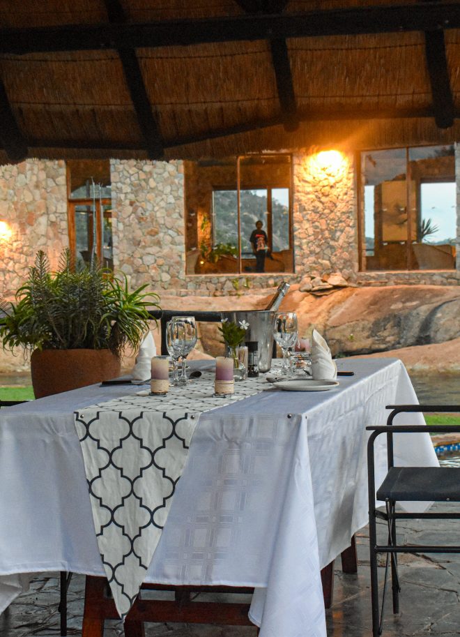 Candle-lit dinner table set on the granite terrace