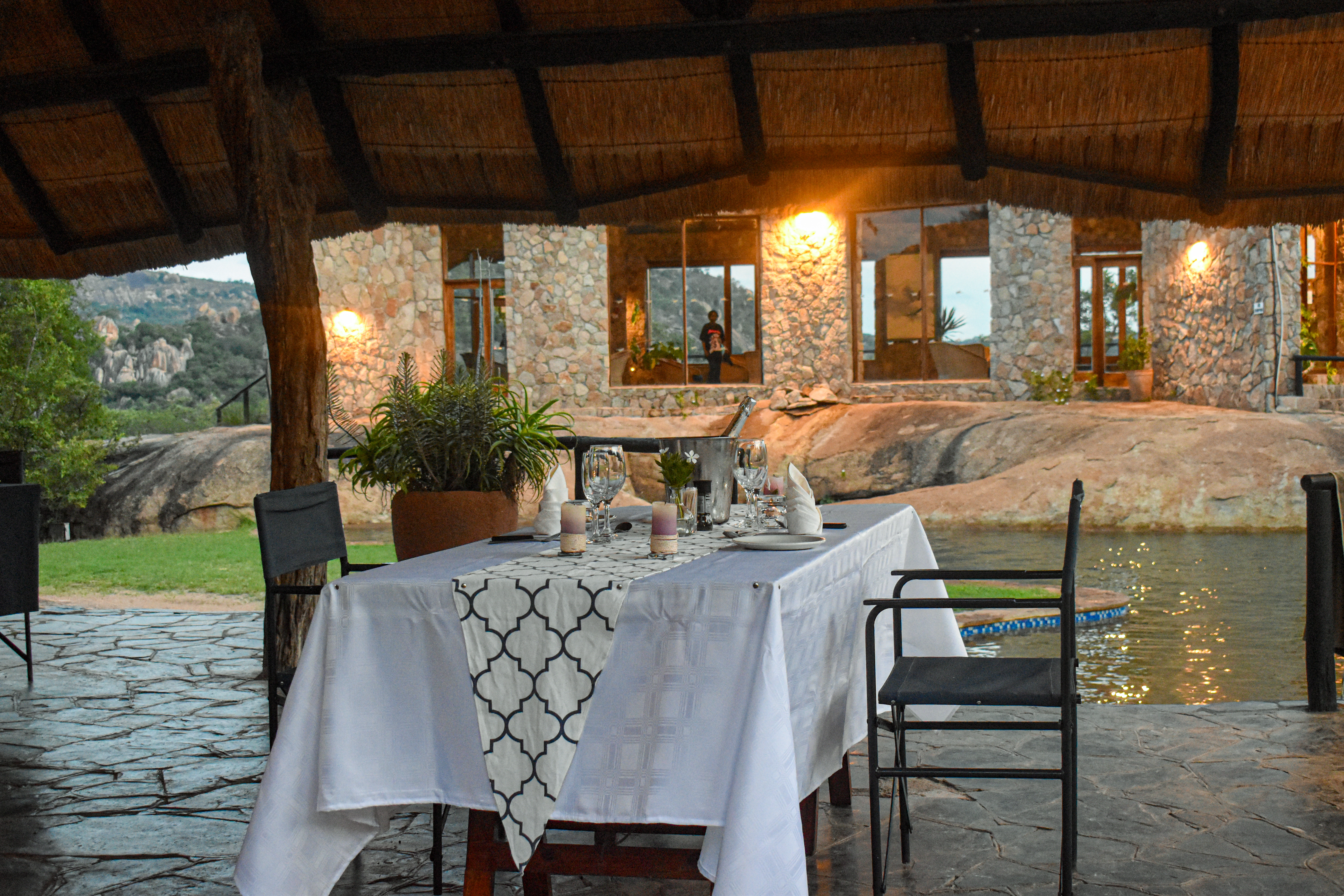 Candle-lit dinner table set on the granite terrace