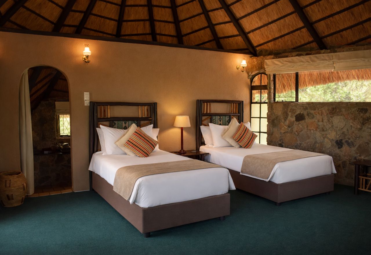 Twin chalet interior with two single beds and stone walls