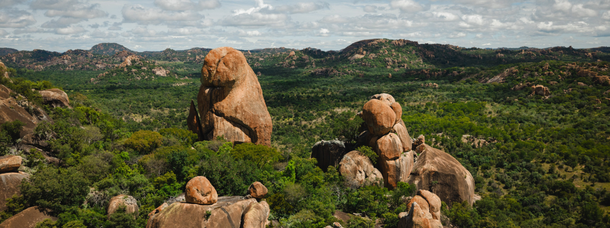 Balancing granite boulders above a sea of green woodland, with more kopjes to the horizon