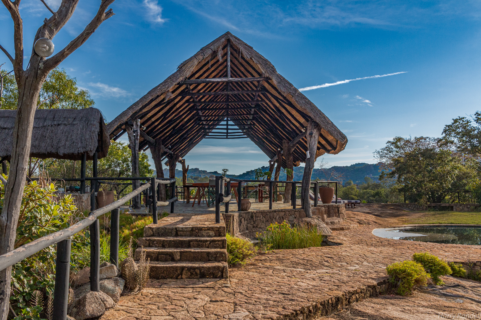 Thatched open-air gazebo with stone steps and plunge pool overlooking the Matobo Hills