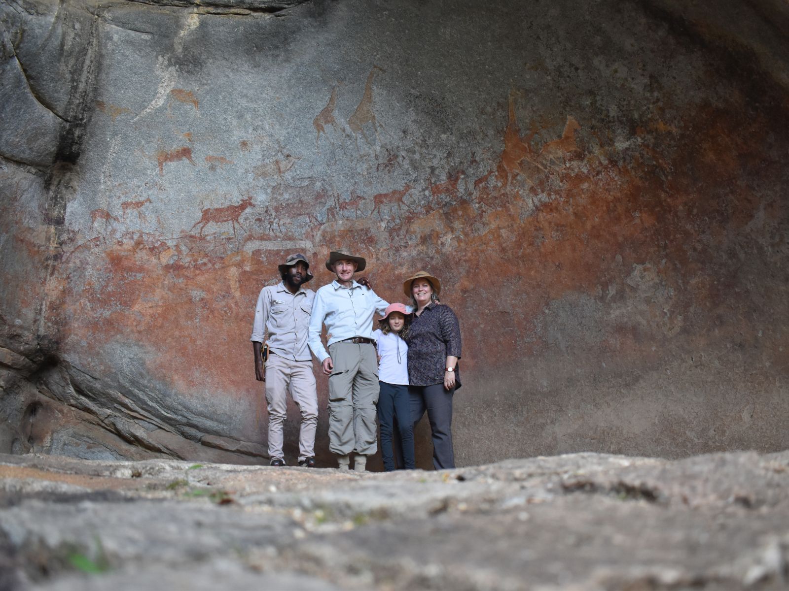 Guide explaining a San rock art panel inside a Matobo cave