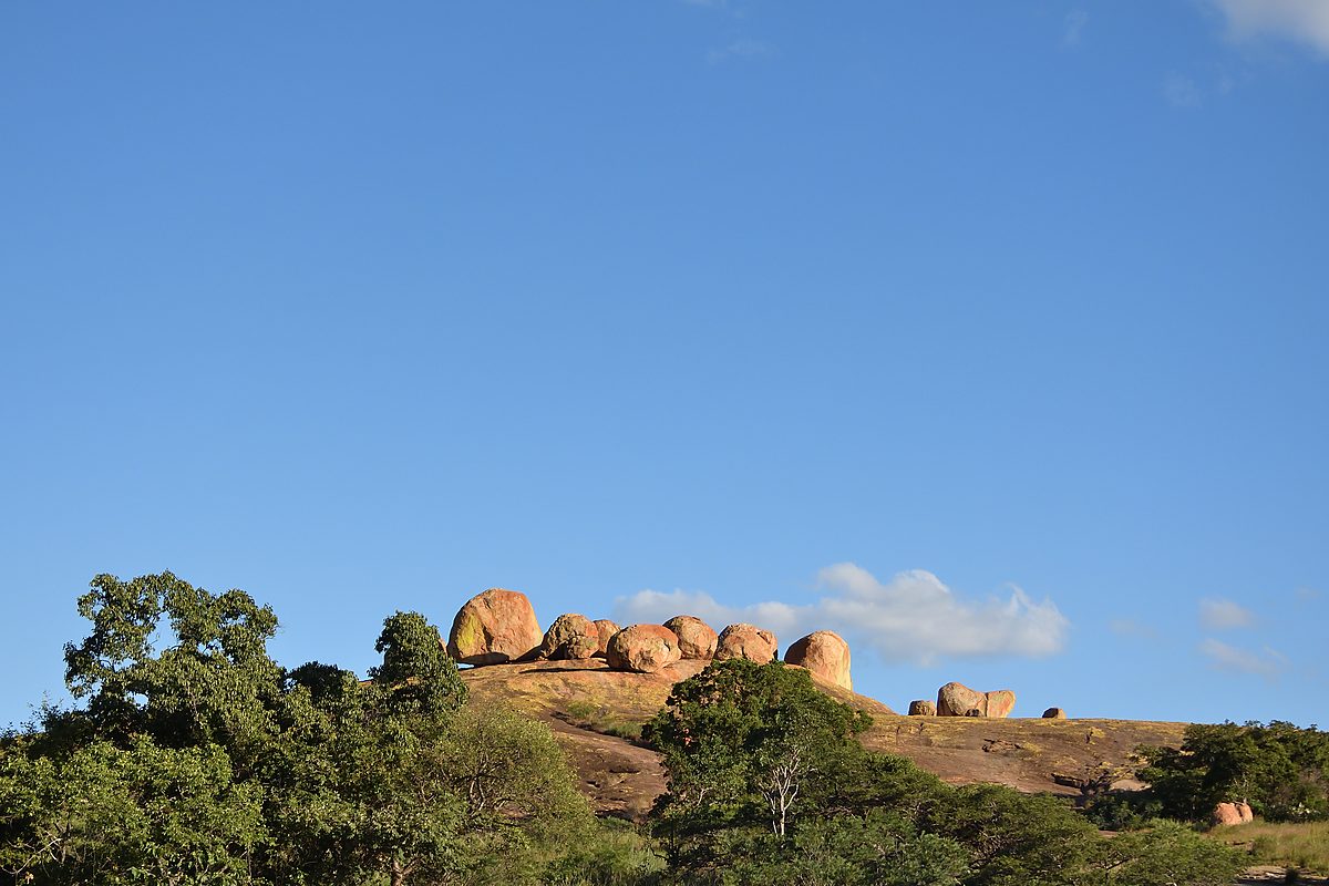 Guests climbing granite toward World's View in Matobo