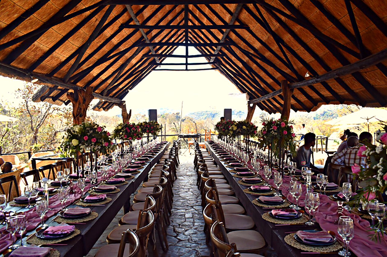 Long wedding reception table laid under the thatched boma at Matobo Hills Lodge.