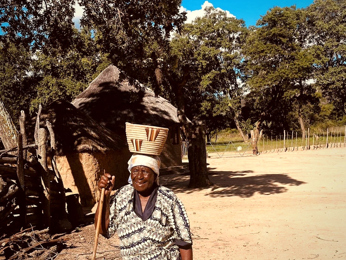 Gogo Dube with a woven basket at her homestead