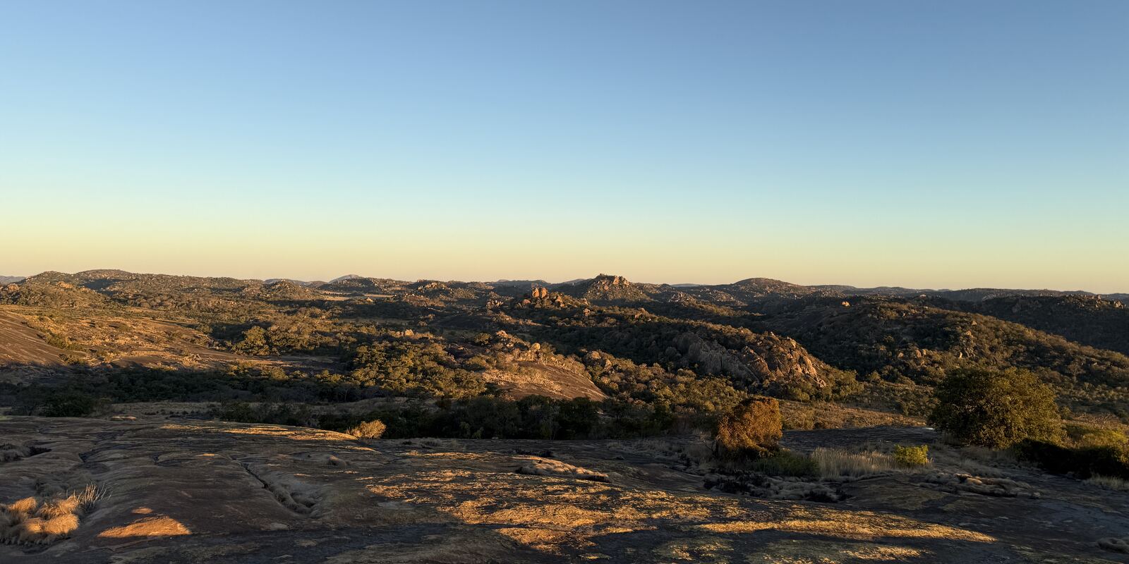 The view from the summit of World’s View: low granite domes running to a flat horizon in evening light